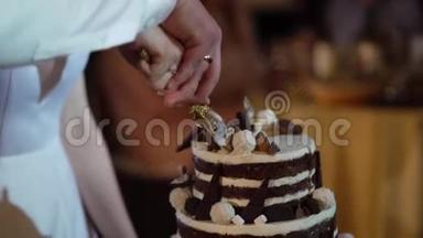 结婚蛋糕。 派对上传统的庆祝甜点。 新郎新娘切块