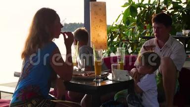 一家人在海滩上的餐馆吃饭。