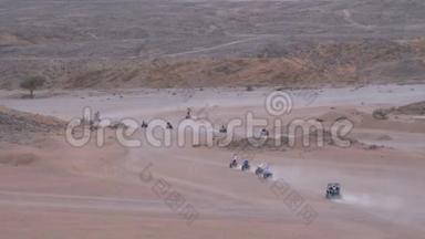 在埃及的沙漠中骑四方自行车小组，以山脉为背景。 驾驶ATV。