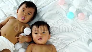 快乐的双胞胎宝宝在床上玩<strong>彩球</strong>