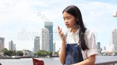 泰国学生青少年美女接电话微笑。