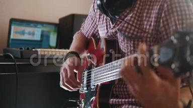 年轻的音乐家用电脑和键盘作曲并记录演奏电吉他的音乐