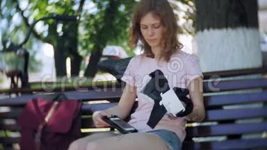年轻女子在公园里使用头戴式显示器。 <strong>玩</strong>游戏使用<strong>VR</strong>头盔智能手机。 快乐