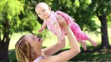 快乐的妈妈在公园里和她的宝贝女儿玩