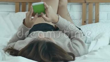 快乐的亚洲<strong>女人</strong>早上在床上使用智能<strong>手机</strong>。 亚洲<strong>女人</strong>在床上用智能<strong>手机</strong>检查社交应用程序。
