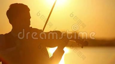日落时分，男小提琴手在湖边拉小提琴