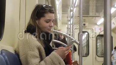年轻的黑发女人乘坐公共<strong>交通工具</strong>，带着耳机使用电话