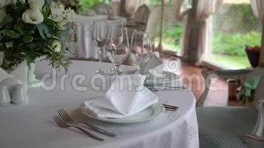 眼镜，盘子，<strong>餐具和餐巾</strong>纸。 为聚会装饰了鲜花的桌子。 婚宴，生日