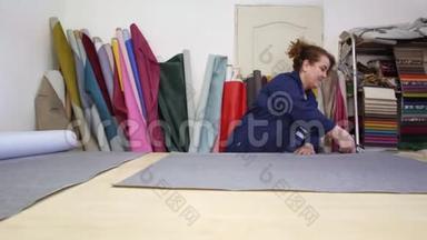 一家家具厂的一位年长妇女正在为沙发切割灰色材料