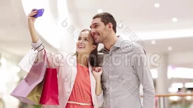 有智能手机的快乐情侣在商场自拍