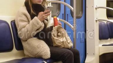 年轻的黑发女人乘坐<strong>公共交通工具</strong>，带着耳机使用电话