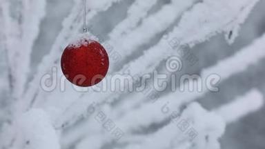 新年。 圣诞节和<strong>装饰品</strong>。 一个<strong>红色</strong>的玩具圣诞老人在森林里的树枝上摇摆。 下雪