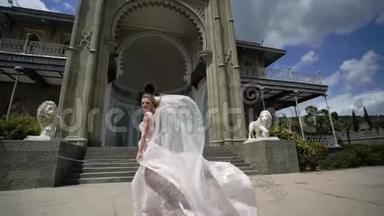 年轻的新娘在城市里摆姿势。 在<strong>刮风</strong>的夏日挥舞面纱。