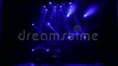 蓝色聚光灯在黑暗中的一个空音乐会舞台上。 舞台灯光。