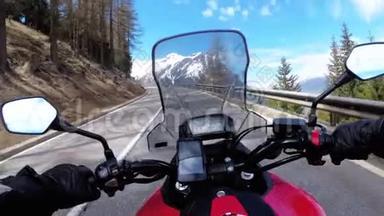 骑摩托车的人骑在瑞士雪山附近美丽的山道上