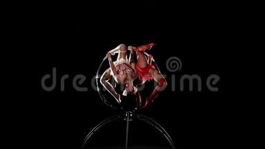 两个女孩在舞台上用<strong>铁环</strong>旋转。黑色背景。慢动作