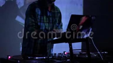 DJ在夜总会<strong>的</strong>迪斯科舞厅里刮擦唱片和在甲板上混音