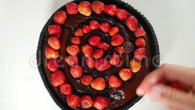 把新鲜的草莓放在装饰蛋糕上，配上巧克力。