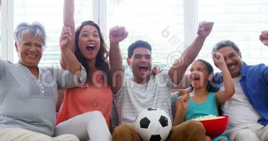 一家人坐在沙发上看足球赛