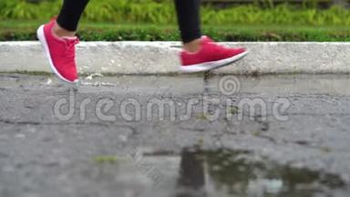 穿<strong>运动鞋</strong>的跑步者的腿。 运动女人在<strong>户外</strong>慢跑，踩在泥泞的水坑里。 单跑运动员在雨中奔跑
