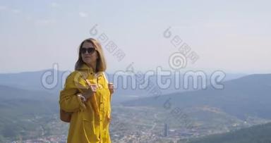 徒步旅行者背着背包在<strong>山顶</strong>徒步旅行。 穿着黄色雨衣的女孩在<strong>山顶</strong>上