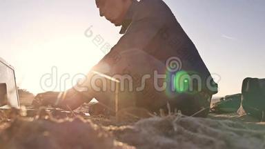 自由职业者。 个人剪影工作在笔记本电脑自由职业者坐在沙滩日落阳光
