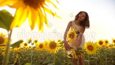可爱的女孩在黄色的花园向日葵阳光在夏天。 美丽的日落小女孩向日葵。 慢慢慢慢