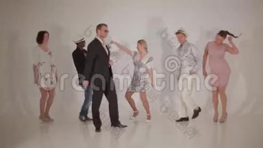 三个可爱的女人和三个迷人的跨种族男人在白色的工作室跳舞