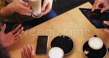 朋友在喝咖啡时使用<strong>手机</strong>和<strong>数码</strong>平板电脑