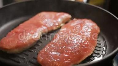 煎牛排肉.. 特写镜头。 煎锅里的猪肉