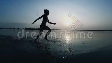 <strong>日</strong>落时沿着海滩奔跑的快乐<strong>儿童</strong>剪影。 慢动作