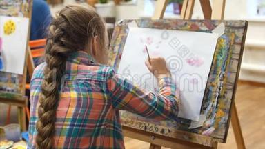 年轻<strong>可爱</strong>的女艺术家在一个艺术工作室，坐在一个Easel和绘<strong>画画</strong>布。 绘图过程：