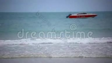 海滩上的<strong>红船</strong>。 多云期间的海浪