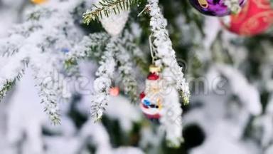 在冬天的森林里，在灯光的背景下，在白雪覆盖的活泼的树上特写一个圣诞玩具。 小型自由度
