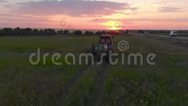 日落时用新鲜的、年轻的土豆灌溉田间拖拉机的鸟瞰图。