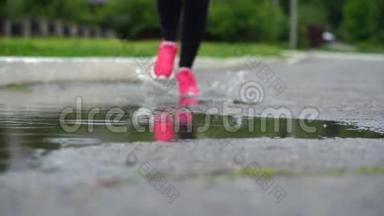 穿<strong>运动鞋</strong>的<strong>跑步</strong>者的腿。 运动女人在户外慢跑，踩在泥泞的水坑里。 单跑运动员在雨中奔跑