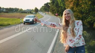 年轻女子在乡间路上搭便车。