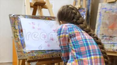 年轻<strong>可爱</strong>的女艺术家在一个艺术工作室，坐在一个Easel和绘<strong>画画</strong>布。 绘图过程：