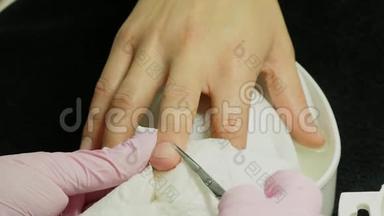特写镜头：一名妇女在美甲沙龙接受美容师用指甲锉修指甲。修指甲的女人