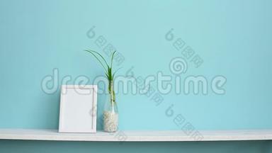 现代客房装饰与相框模型。 白色的架子靠在粉绿色的墙壁上，上面有蜘蛛<strong>植物</strong>的插条，在<strong>水中</strong>