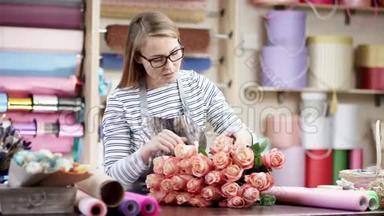 快乐的花店女用纸包花。 她试图用一束美丽的花束<strong>谱写</strong>花朵