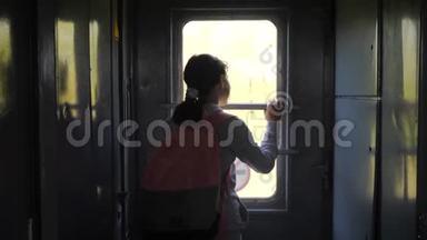 小女孩是一个乘火车旅行的背包客。 旅游运输铁路概念。 旅游学校女孩