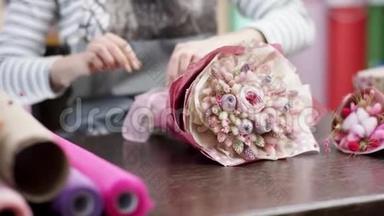 快乐的花店女用纸包花。 她试图用一束美丽的花束<strong>谱写</strong>花朵