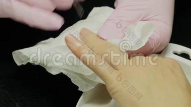 特写镜头：一名妇女在美甲沙龙接受美容师用指甲锉修指甲。修指甲的女人