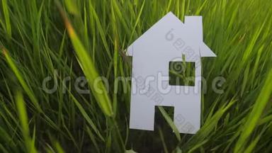 建设幸福家庭建设住宅理念.. 纸屋矗立在生活方式中，绿色的草在大自然中。 象征生命