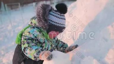 一个<strong>小孩</strong>子正在<strong>冬天</strong>的公园里玩雪。 晴朗的冬日。 新鲜空气中的乐趣和游戏。