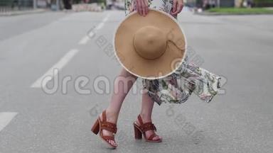 美丽的金发女郎戴着帽子在城市里<strong>走来走</strong>去。