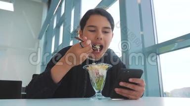机场等待飞机航班.. 十几岁的女孩吃沙拉，看上去像智能手机。 在咖啡馆里上网。 机场