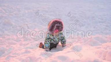 一个小孩子在冬天公园玩。 晴朗的冬日。 新鲜空气中的乐趣和游戏。