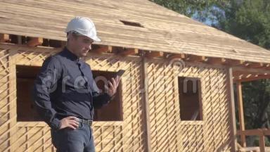 概念建筑构建建筑师慢动作视频.. 戴着头盔的男建筑工人站在建筑工人手中
